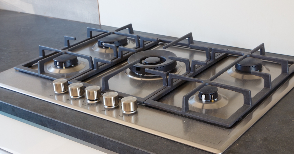 Modern gas cooktop with stainless steel finish. Troubleshooting why a cooktop won’t turn on—common causes include faulty ignition switches, power supply issues, or clogged burner ports